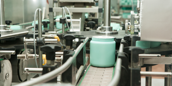 Cosmetic cream jars moving through an automated packaging line