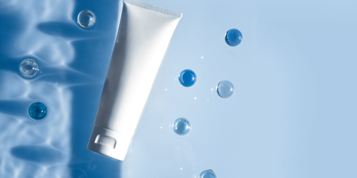Mavi su efekti üzerinde beyaz tüp formunda kozmetik ürünü.