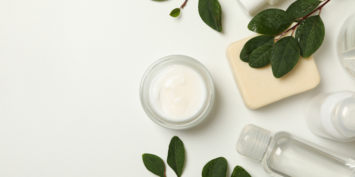 Баночка для косметического крема, мыло и средства по уходу за кожей со свежими зелеными листьями.