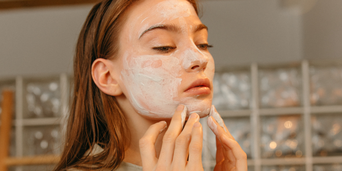 Женщина наносит маску для ухода за кожей